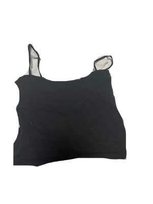 Svart croppad linnetopp - Snygg svart croppad linnetopp med axelbanden. Perfekt för en trendig och ungdomlig stil. Enkel att matcha med både jeans och kjol.