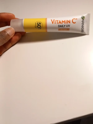 Garnier Vitamin C Daily UV SPF50+ 40ml - Garnier Vitamin C Daily UV är en ansiktskräm med SPF50+ som ger glow och skyddar mot solen. Tuben är vit och gul med orange detaljer och rymmer 40 ml. Perfekt för dig som vill ha både solskydd och lyster i din basrutin.