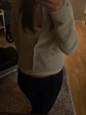 Beige kofta från Kappahl - Mysig beige kofta från Kappahl med rund halsringning och knappar framtill. Koftan har långa ärmar och ribbade muddar vid ärmslut och nederkant. Tillverkad i ett mjukt, stickat material. Pris kan alltid diskuteras!💞