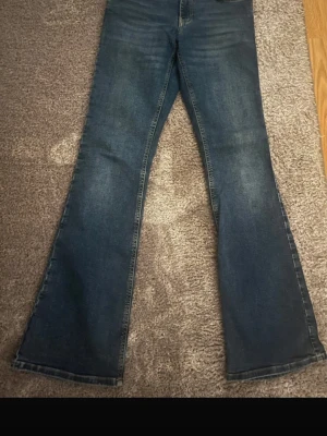 Mörkblå bootcut jeans - Säljer ett par snygga mörkblå bootcut jeans med klassisk femficksdesign. Jeansen är bootcut och normal midja. Perfekta för dig som gillar en avslappnad stil. 
