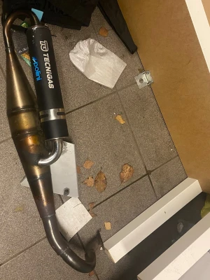 Technigas NeXT-R avgasrör - Technigas Next-R sportavgassystem till pgo 50cc 2-takt.   Suttit på PGO Big Max men passar flera PGO modeller som hot 50, G-Max, PMX, T-Rex m.fl.  Bra skick, endast vanlig missfärgning från värme. Pluggen och några monteringsskruvar saknas.  Kan passa fler modeller som Yamaha osv kolla upp de isåfall.  Endast en polering krävs på röret för att få det skinande rent. Samt pluggen i ljuddämparen är kvar.  Pris 900kr eller bud