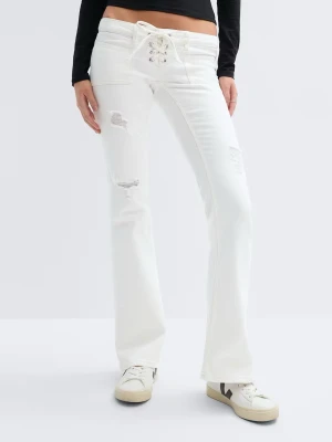 Vita bootcut jeans med snörning - Säljer ett par vita bootcut jeans med snörning i midjan och slitna detaljer på benen. Jeansen har hög midja och vida ben. Passar både M men också S💕