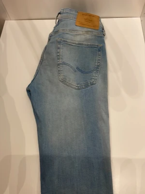 Ljusblå jeans från Jack & Jones - Ljusblå jeans från Jack & Jones med klassisk femficksdesign och snyggt läderpatch bak. Jeansen har en slim fit passform och är tillverkade i mjukt denim-material. Perfekta för dig som gillar en avslappnad och modern look.