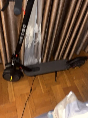 Svart elscooter från Zwheel kör 30km - Säljer en svart elscooter från Zwheel med bred fotplatta och robusta hjul. Scootern har en mobilhållare på styret och laddas via kabel. Perfekt för smidig transport i stan eller till skolan.