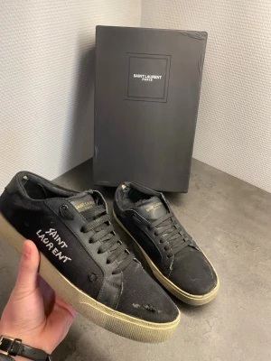 Saint Laurent skor // ysl - Tja, säljer nu ett par riktigt schyssta saint lauren skor till sommarn!    ////Skick////  7/10. Super bra förutom lite släpp inne i skon vid hälen och sulan. Sular är lagad och inget vatten eller smuts kommer in  //// storlek //// 40 men passar 41.  Inga större skador än de som visas på bilden.  (Hälen)  Nypris 6000+🫣.   Hör av er vid minsta lilla!  MVH/ hampus🤗