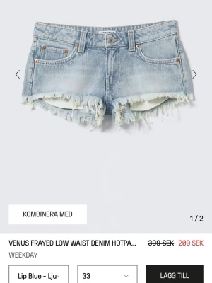 Ljusblå fransiga jeansshorts Weekday - Säljer ett par ljusblå denimshorts från Weekday med låg midja och fransiga kanter. Klassisk femficksmodell med knapp och dragkedja framtill. Perfekta för sommaren och ger en avslappnad vibe.