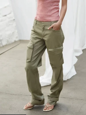 Olivgröna cargobyxor med fickor - Säljer ett par olivgröna cargobyxor med raka ben och stora sidofickor. Byxorna har en avslappnad passform och klassiska cargodetaljer. Perfekta för en cool och avslappnad stil. Materialet känns slitstarkt och bekvämt. De är helt nya råka dubbelbeställa så fick ett par över. Är 174 och de passar mig. 