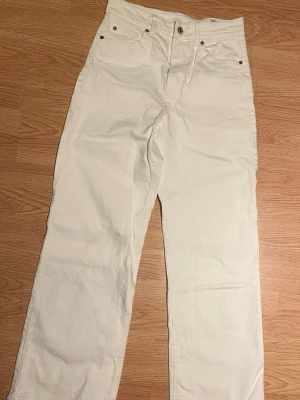 Vita vida jeans från H&M stl 40. SOM NYA! - Säljer ett par vita jeans från H&M i rak modell med normalhög midja. Klassisk femficksdesign och knappgylf. Perfekta till en clean och stilren look. Materialet är mjukt och bekvämt, passar till många olika outfits. Använda endast en gång på ett white-party.