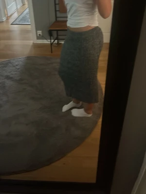 Grå ribbad långkjol - Säljer en grå ribbad långkjol med stretchig passform. Kjolen har en enkel och stilren design som passar perfekt till både sneakers och boots. Materialet känns mjukt och bekvämt mot huden.