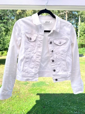 Stilren vit jeansjacka från Even&Odd, storlek xs - Säljer min vita stilrena jeansjacka från Even&Odd i storlek XS, som tyvärr blivit för liten för mig. Supersnygg till jeans 👖Knappt använd - accepterar alla bud! Längd: 48cm - Axel: 39cm
