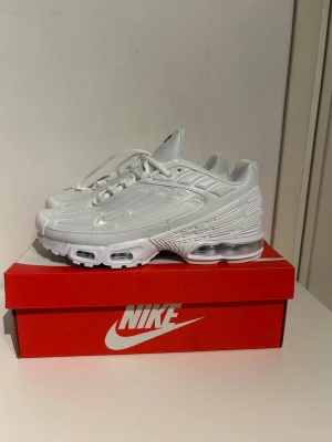 Nike Air Max Plus 3 vita sneakers - Nike Air Max Plus sneakers i helvitt med klassisk TN-logga på plösen. Skorna har en futuristisk design med synlig Air Max-dämpning i sulan och detaljer i syntetmaterial och mesh. Perfekta för dig som gillar streetwear och sportig stil.