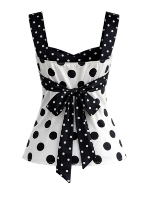 Prickig svartvit topp med rosett - Snygg topp i svart och vitt med stora prickar och breda axelband. Toppen har en markerad midja med en stor rosett framtill och ett sött sweetheart-urringning. Perfekt för dig som gillar retrovibbar och vill sticka ut.