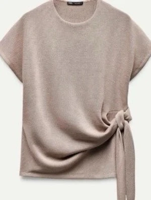 Beige topp med knyt i sidan - Zara - Snygg och fin tröja från Zara, jätte skön tröja. Säljer då den inte används, finns inga defekter. Hör av dig för fler frågor!💕