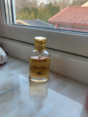 La Rive Vanilla Touch parfym - La Rive Vanilla Touch är en parfym i en genomskinlig glasflaska med guldfärgat lock. Doften har tydliga inslag av vanilj och flaskan har en elegant, rundad form med guldtext och en liten vaniljblomma på framsidan. Använd en gång men inget mer för tycker inte doften passar mig.