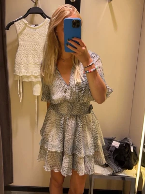 Mönstrad klänning från Zara - Supersöt kort klänning från Zara med volangdetaljer. Klänningen har ormskinnsmönster med v-ringning och korta ärmar med volang. Perfekt för sommarens alla tillfällen!