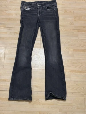Mörkblå bootcut jeans Gina Tricot - Snygga mörkblå bootcut jeans från Gina Tricot med klassisk femficksmodell och kontrastsömmar. Jeansen har en lätt tvättad look och är tillverkade i mjukt denimtyg. Perfekta för en avslappnad och trendig stil.