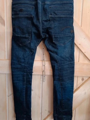 Mörkblå G-Star D-Staq jeans - Säljer ett par mörkblå G-Star D-Staq jeans med smal passform och snygga slitningar. Jeansen har flera fickor både fram och bak, dragkedjegylf och klassiska G-Star detaljer. Perfekta för dig som gillar streetwear och modern stil.