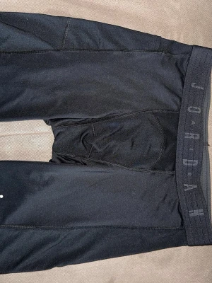 Svarta Jordan cykelbyxor - Säljer ett par svarta cykelbyxor från Jordan med bred resår i midjan där märket står tryckt. Materialet är stretchigt och passar perfekt för träning eller sportiga outfits.