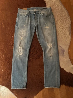 Dondup george slitningar - Säljer ett par dondup George i storlek 34. med slitningar och fades. Hör av dig vid minsta fundering!