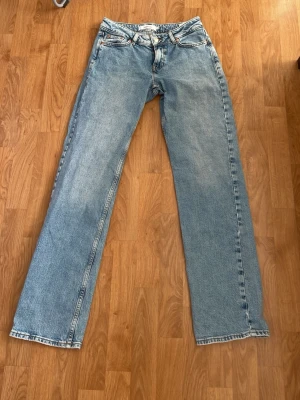 Ljusblå straight low jeans från Junkyard - Säljer ett par ljusblå jeans som e lågmidjade och raka i psssformen  från Junkyard. De är som helt nya, då de har aldrig varit använda så de är endast testade och har inga defekter eller tecken på användning. (Tredje och fjärde bilden e lånad) (Nypris: 599kr)