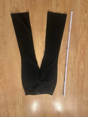 Svarta kostymbyxor med raka ben - Snygga svarta kostymbyxor med raka ben och klassisk passform. Byxorna har hällor för skärp och två bakfickor utan lock. Perfekta för en stilren och clean look. Materialet ser ut att vara en mjuk och lite stretchig blandning, vilket gör dem bekväma hela dagen.