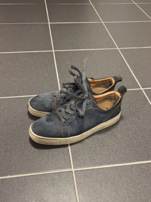 Blåa låga sneakers med röd sula - Blå Christian Louboutin skor, smutsiga och har små hål på sidan, inget stort och går även att fixa