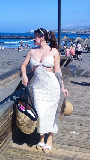 Vit virkad strandklänning med cut-outs - Snygg vit virkad strandklänning med smala axelband och trendiga cut-outs vid midjan. Klänningen är hellång och har en slits bak för extra rörelsefrihet. Perfekt att dra över bikinin på stranden för en chic och avslappnad look.