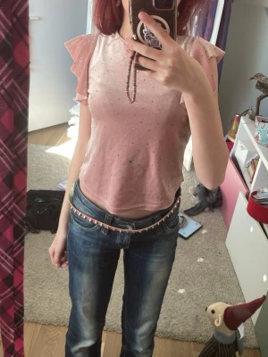 Söt askrosa topp med glitter ✨  - Söt rosa topp med volangärmar och små pärlor över hela tyget. Toppen är croppad och har en mjuk, glittrig finish som ger extra detalj. Perfekt för dig som gillar gulliga och trendiga plagg.💖