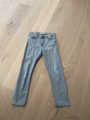 Grå raka jeans från Weekday - Säljer ett par grå jeans från Weekday med rak passform och klassisk femficksdesign. Jeansen har normal midja och är tillverkade i denim med en snygg tvättad look. Perfekta för en avslappnad och trendig stil.