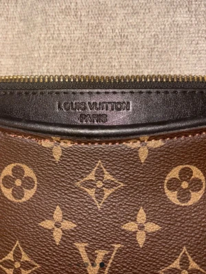 kuvertväska/ clutch  - Säljer en klassisk brun kuvertväska med ikoniskt monogrammönster. Väskan är tillverkad i canvas med detaljer i läder och har präglad logotyp på insidan. Dragkedjanr sönder och går inte att stänga!! Är inte äkta men ser identisk ut.