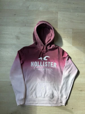 Rosa och Vit Hollister Hoodie Storlek S - Fin Hollister tröja i vit och rosa färg. Tröjan är i mycket bra skick, tyvärr 2 små fläckar (SE SISTA 2 BILDER) och sparsamt använda. |  Äkta som allt annat jag säljer! ✅ |  Storlek: S | Skick: Mycket Bra Skick - 2 små fläckar, går nog bort med rätt medel (SE SISTA 2 BILDER)  | Färg: Rosa | Märke: Hollister | Modell: Hoodie |  Hör gärna av dig vid frågor så svarar jag så fort jag kan! 😁|  (SKU-77)