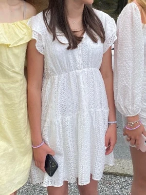 Vit spetsklänning med volangärm till student/midsommar/skolavslutning - Söt vit kortklänning med spetsdetaljer och volangärmar. Klänningen har v-ringning och ett luftigt, avslappnat fall men dubbelttyg vid kjolen så den inte är genomskinlig. Perfekt för både student, skolavslutning, midsommar eller bara en sommarkväll💕 Använd 2-3 gånger, så mycket bra skick! 💕