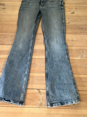 Blå bootcut jeans  - Säljer dessa blåa bootcut jeans med låg midja från Gina Tricot. Passar mig som är 170 bra i längden. Mycket bra skick, har nästan aldrig använt dem💕Ser mer gråa ut på bilden än i verkligheten. Storlek 38.