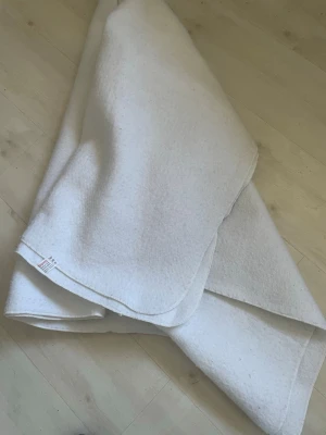 Vit innertäcke  från Bova Borgstena - Mjuk och tjock vit filt från Bova Borgstena Vaddfabrik, tillverkad i Sverige. Filtens material känns fluffigt och har rundade hörn med sydd kant. Perfekt att ha i soffan eller som extra lager i sängen.