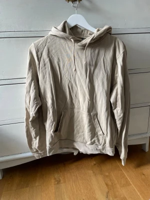Beige hoodie med ficka framtill - Beige hoodie som är sparsamt använd 