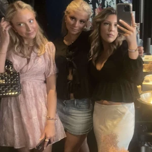 Ljusrosa omlottklänning med volang - Söt ljusrosa kortklänning med omlott-design och volangdetaljer. Klänningen har puffiga kortärmar och ett knyt i midjan som framhäver siluetten. Perfekt för dig som vill ha en feminin och trendig look.