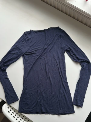 Mörkblå långärmad topp Intimissimi - Säljer en tunn och mjuk mörkblå långärmad topp från Intimissimi. Toppen är ultralätt och innehåller kashmir för extra komfort. Enkel och stilren design som passar perfekt till lager på lager eller som basplagg.