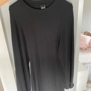 Klänning med tajt midja - En enkel och stilren svart långärmad klänning från Gina Tricot. Modellen har rund halsringning och är gjord i mjukt material som passar perfekt till alla outfits. Perfekt basplagg för garderoben.