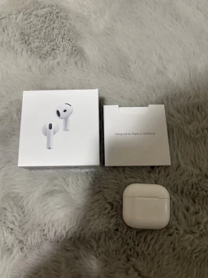 Apple AirPods Pro trådlösa hörlurar - Säljer ett par vita Apple AirPods Pro med trådlöst laddningsetui. Hörlurarna har en stilren och kompakt design i blank plast och levereras med originalförpackning. Perfekta för dig som vill ha grymt ljud och smidig anslutning till din iPhone eller andra Apple-enheter.