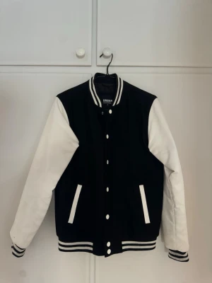 Collegejacka - Collegejacka i fint skick. Från märket Urban Classics med storleken M. Frågor eller funderingar? Bara att skriva. Materialet är relativt tjockt. 