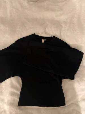 Svart långärmad topp  - En enkel svart långärmad topp. Modellen är figurnära.