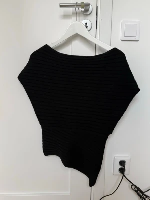 Svart asymmetrisk stickad tröja - Jättefin stixkad topp med one shoulder. Var jätte populär för ett tag sen men är nu slutsåld och finns inte att köpa längre. Helt ny och aldrig använd endast testad, har bara legat i garderoben🩷
