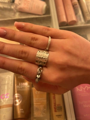 norbottens ring, bred silverring med pärldetaljer - Säljer en bred silverfärgad norbottens ring med upphöjda pärldetaljer och graverat mönster runt om. Ringen har en cool boho-vibe och passar perfekt för dig som gillar statement-smycken. Materialet är metall i silverton.