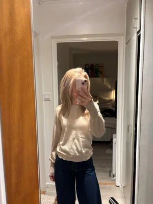 Neo Noir. Beige stickad tröja med rund hals - Mysig beige stickad tröja med rund hals och långa ärmar. Tröjan har ribbade muddar vid ärmslut och nederkant, vilket ger en snygg och enkel look. Perfekt att matcha med jeans eller kjol för en clean stil!!! 