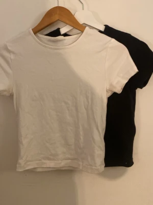 2-pack basic t-shirts Gina Tricot - Två basic t-shirts från Gina Tricot i svart och vitt. Modellen är klassisk med rund hals och korta ärmar. Perfekta att matcha till allt och tillverkade i mjuk bomull för skön känsla hela dagen.