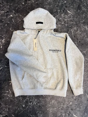 Essentials hoodie - Snygg grå färg och bra passform fraktas samma dag 