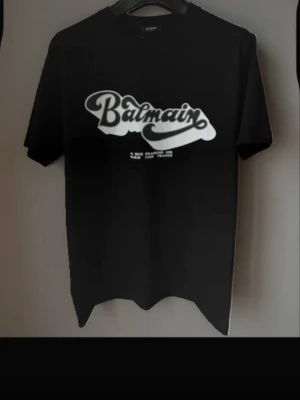 Svart Balmain t-shirt Helt Ny med ettiket - Cool svart t-shirt från Balmain med stor vit logga framtill i retrostil. Klassisk rund halsringning och korta ärmar. Perfekt för dig som vill ha en stilren och trendig look med exklusiv känsla.  finns i exakt samma fast i vit färg!!