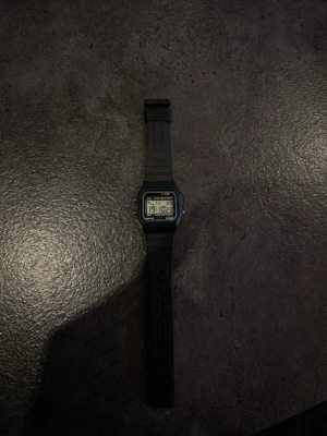 Svart digital klocka  - Klassisk digital klocka med svart plastarmband och rektangulär display. Klockan har tydlig digital tidvisning och enkel design som passar till allt. Perfekt accessoar för dig som gillar retrostil och funktion.