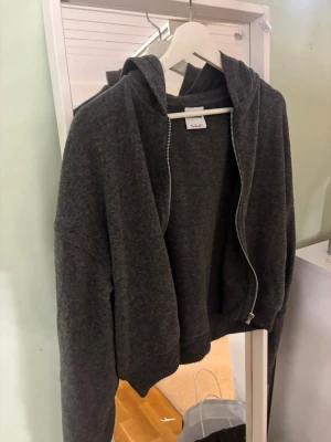 Mörkgrå zip up tröja - Mysig mörkgrå hoodie från Berschka med dragkedja framtill. Tillverkad i mjukt ”fleece” material ungefär,  och har en klassisk huva. Är i storlek L men passar mig med storlek S/M, Aldrig använd💕