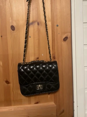 Svart quiltad handväska med kedjerem - Svart handväska från ur och Penn som aldrig är använd. 